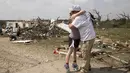 Michelle Light memeluk pamannya Paul Bales sehari setelah tornado menghancurkan rumahnya di FM 2843 dan Cedar Valley Road dekat Salado, Texas (13/4/12). Sekitar puluhan orang terluka akibat tornado yang melanda Texas tengah. (Jay Janner/Austin American-Statesman via AP)