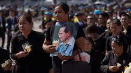 Kesedihan sejumlah warga saat upacara kremasi mendiang Raja Bhumibol Adulyadej di Bangkok, Thailand, Kamis, (26/10). Prosesi kremasi Raja Bhumibol dilaporkan telah menelan biaya hingga Rp1,2 triliun. (AP Photo/Gemunu Amarasinghe)
