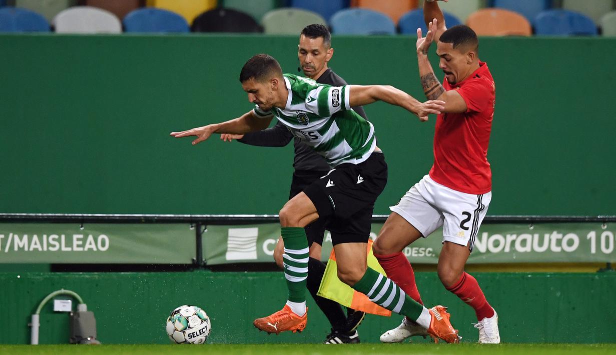 Bek Sporting Lisbon, Zou (kiri) menguasai bola dibayangi bek Benfica, Gilberto Junior dalam laga lanjutan Liga Portugal 2020/21 di Jose Avalade Stadium, Lisbon, Senin (1/2/20201). Sporting menang 1-0 atas Benfica. (AFP/Patricia De Melo Moreira)
