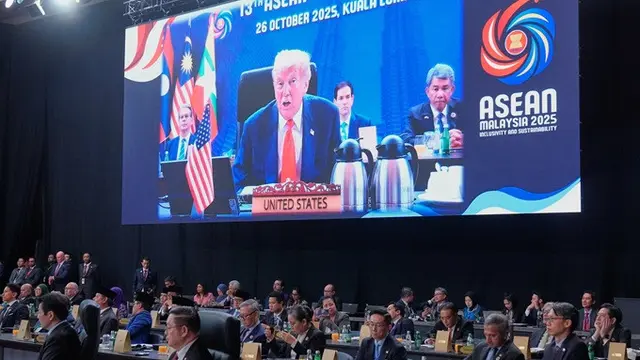 Presiden Amerika Serikat Donald Trump terlihat di layar video saat menyampaikan pidato dalam salah satu sesi kerja KTT ASEAN di Kuala Lumpur, Malaysia, Minggu (26/10/2025).