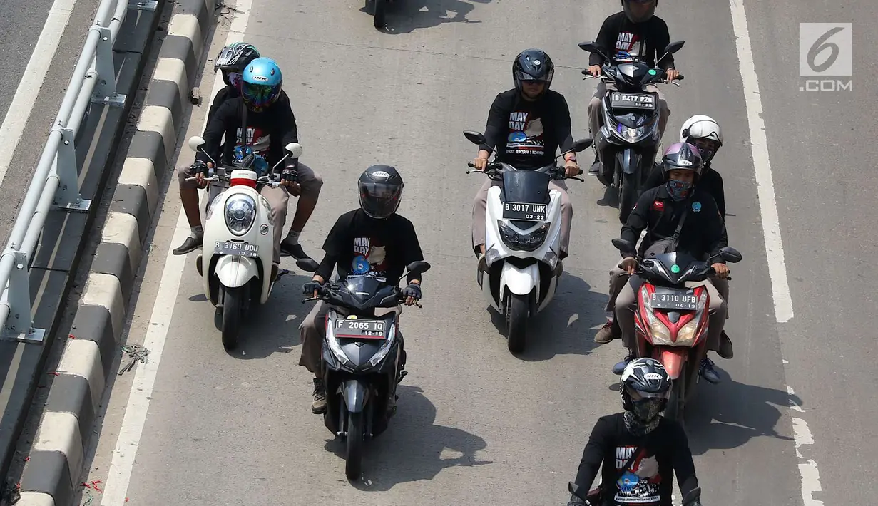 Konvoi buruh menggunakan sepeda motor melintas di Jalan Gatot Soebroto, Jakarta, Selasa (1/5). Ribuan buruh dari berbagai elemen memperingati perayaan Hari Buruh untuk menyampaikan aspirasi di sejumlah titik di Ibukota. (Liputan6.com/Immanuel Antonius)