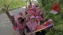 Wajah ceria anak-anak sekolah menanti para pebalap Tour de Singkarak 2016 saat menuju garis finish di Dharmasraya, Sumatera Barat, (12/8/2016). (Bola.com/Nicklas Hanoatubun)