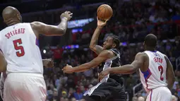 Pemain San Antonio Spurs, Kawhi Leonard (tengah) melakukan tembakan melewati hadangan para pemain L. A. Clippers  pada laga NBA basketball game di Staples Center, (22/12/2016). Clippers menang 106-101. (Reuters/Gary A. Vasquez-USA TODAY Sports)