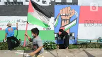 Remaja membuat mural bertema solidaritas untuk Palestina di Gang Jambu, Kedaung, Depok, Jawa Barat, Selasa (18/5/2021). Remaja Majelis Al Muntaqilin membuat mural tersebut sebagai solidaritas serta doa bagi umat muslim Palestina dan Masjid Al Aqsa atas serangan Israel. (merdeka.com/Arie Basuki)