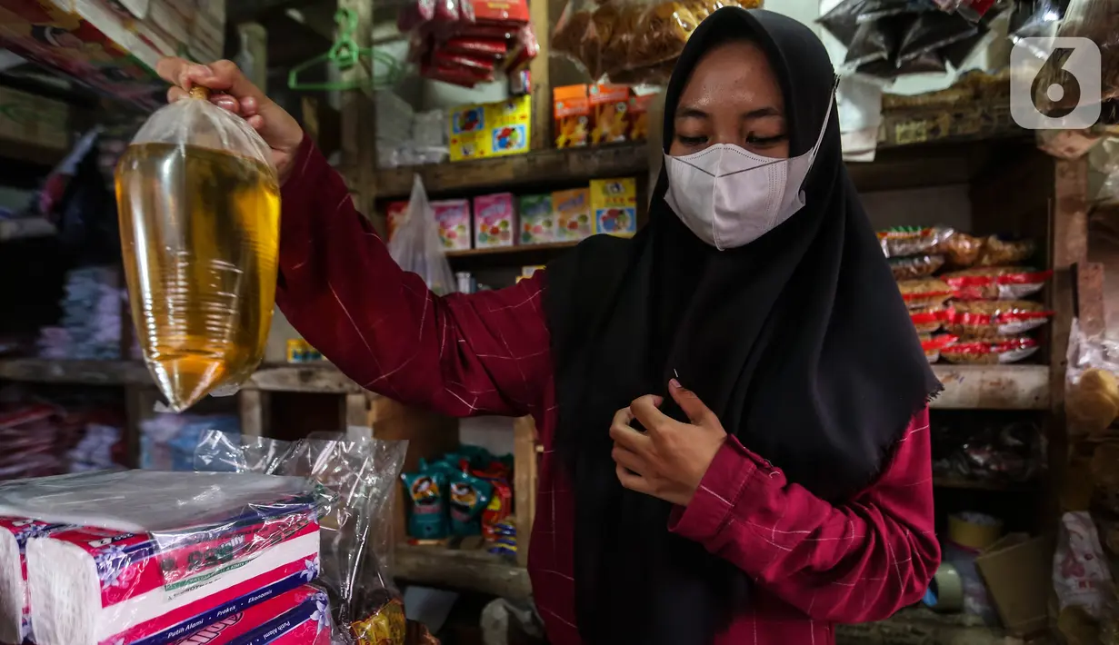 Seorang pedagang menimbang minyak goreng curah di kiosnya Pasar Kebayoran Lama, Jakarta, Rabu (19/1/2022). Pemerintah resmi mengimplementasikan kebijakan minyak goreng satu harga Rp14.000 per liter untuk semua jenis kemasan mulai hari ini. (Liputan6.com/Johan Tallo)