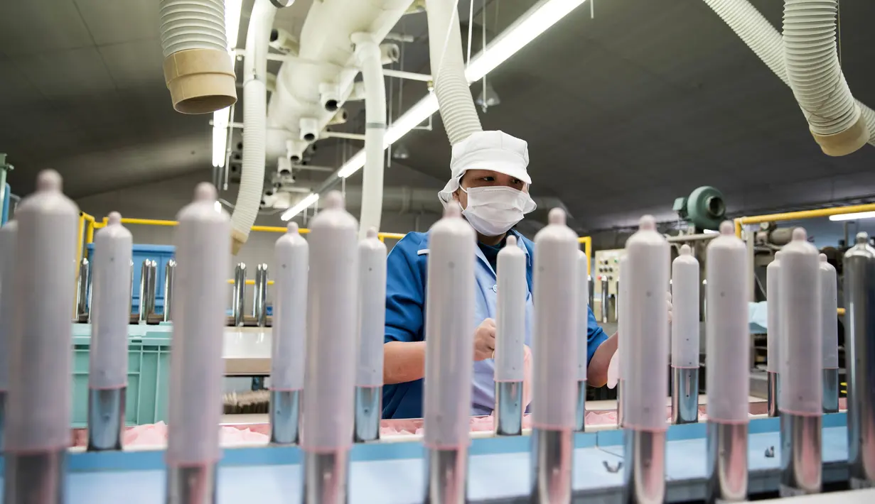 Seorang pekerja melakukan pengujian kualitas kondom di Sagami Rubber Industries, Prefektur Kanagawa, Jepang (25/1). Sambut Olimpiade 2020, Jepang akan memamerkan produk lokal kondom yang ultra tipis. (AFP Photo/Behrouz Mehri)