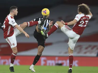 Penyerang Newcastle United, Callum Wilson berebut bola dengan dua pemain Arsenal Granit Xhaka dan David Luiz pada pertandingan Liga Inggris di Stadion Emirates di London, Selasa (19/1/2021). Arsenal menang telak atas Newcastle 3-0. (Adam Davy/Pool via AP)