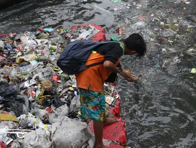 Salah satu petugas UPK Badan Air Dinas Lingkungan Hidup DKI Jakarta mengangkut ceceran sampah di Kali Cideng, Jakarta, Jumat (9/11). Pembersihan untuk mencegah terjadinya penumpukan sampah saat musim hujan di Jakarta. (Liputan6.com/Helmi Fithriansyah)