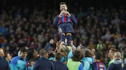 Bek Barcelona, Gerard Pique dilempar ke udara oleh rekan setimnya setalah pertandingan melawan Almeria di stadion Camp Nou di Barcelona, Spanyol, Minggu (6/11/2022).  Gerard Pique resmi meninggalkan Barcelona sekaligus pensiun sebagai pemain sepak bola. (AP Photo/Joan Monfort)