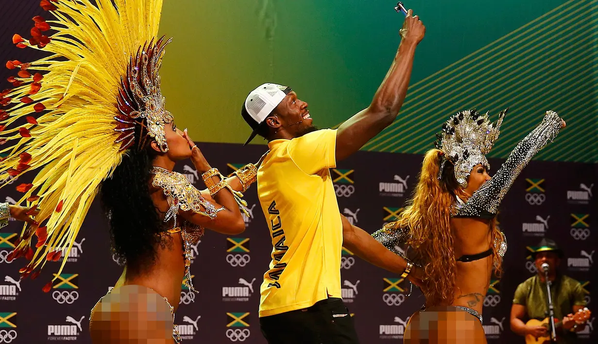 Pelari asal Jamaika, Usain Bolt berselfie dengan penari samba saat konferensi pers cabang atletik Olimpiade Rio 2016 di Rio de Janeiro, Brasil, (8/8). Pelari 29 tahun ini merupakan pelari pria tercepat di dunia. (REUTERS/Nacho Doce)