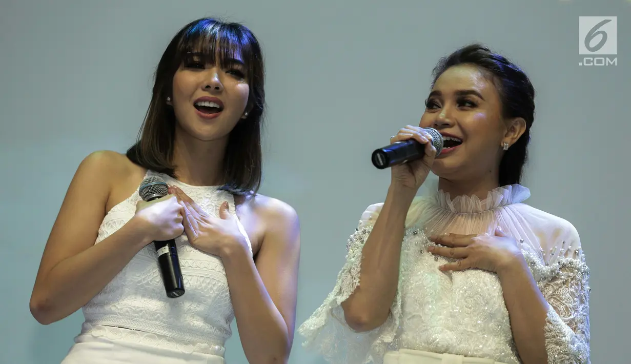 Penyanyi Gisella Anastasia (kiri) dan Rossa (kanan) saat bernyanyi bersama dalam acara konferensi pers Brand Ambassador Oriflame di Jakarta, Kamis (1/2). (Liputan6.com/Faizal Fanani)