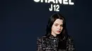 Becky Rebecca tampil dengan setelan hitam tweed dari Chanel, dari atasan blazer dan mini skirt. Sambil membawa sling bag mini. Ia mengenakan jam tangan putih Chanel.  Dok.CHANEL