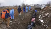 Sejumlah jenazah dimasukkan ke dalam kuburan massal di pinggiran Mariupol, Ukraina, 9 Maret 2022. Warga tidak dapat menguburkan orang mati di antara mereka karena serangan berat oleh pasukan Rusia. (AP Photo/Evgeniy Maloletka)