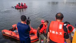 Tim penyelamat mencari korban selamat dari sebuah bus yang jatuh ke danau di Anshun, provinsi Guizhou, China, Selasa (7/7/2020). Sedikitnya 21 orang tewas usai bus yang membawa siswa untuk mengikuti ujian masuk perguruan tinggi atau gaokao itu menabrak pagar pembatas lalu tercebur ke danau (STR/AFP)