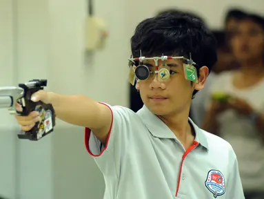 Petembak Junior Indonesia, I Kadek Rico V (kiri) saat laga melawan Abdul Hadi Abd Malek di Final 10m Air Pistol Men Junior Kejuaraan Menembak ASEAN di Jakarta, Rabu (25/11/2015). Kadek meraih emas dengan 196.7 poin. (Liputan6.com/Helmi Fithriansyah) 