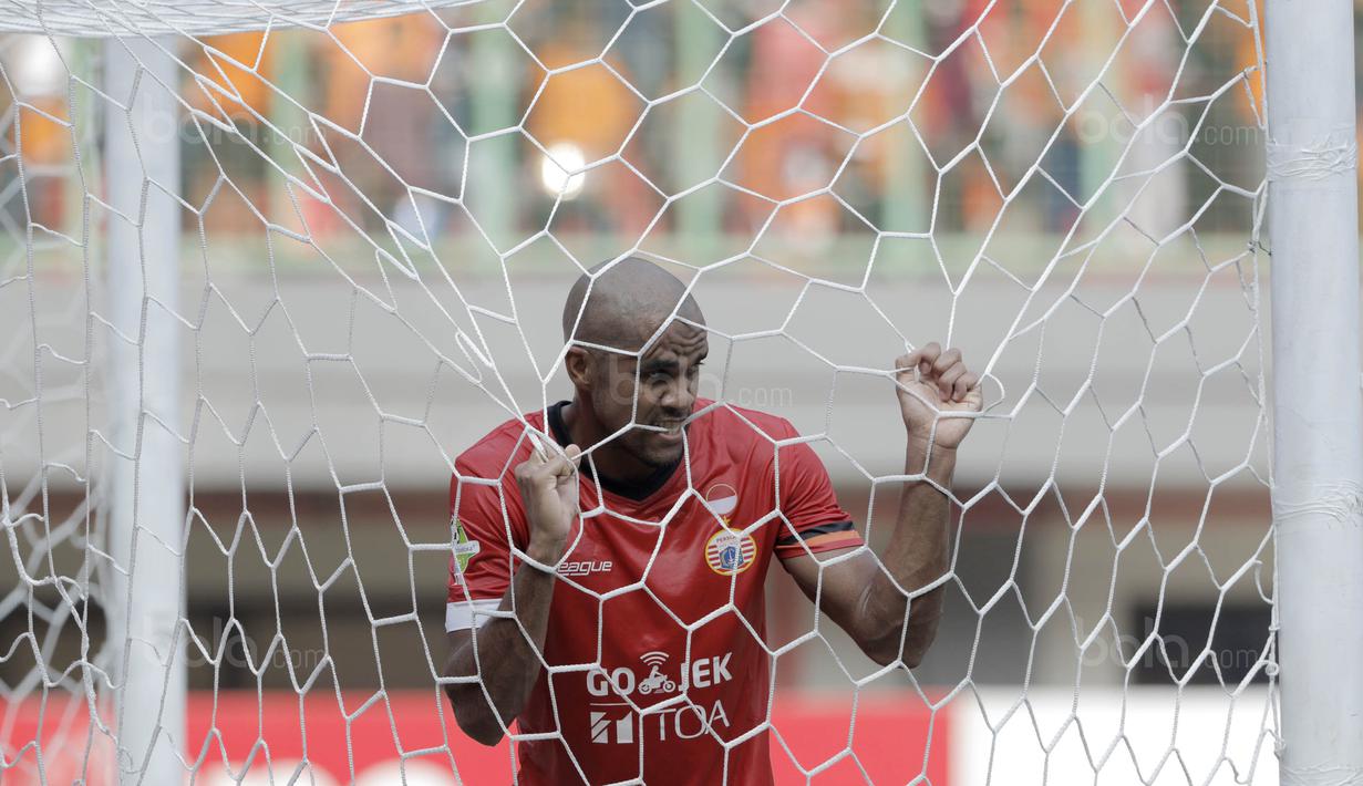 Striker Persija, Reinaldo, menggigit jaring gawang usai gagal menjebol gawang Persiba pada laga Liga 1 di Stadion Patriot, Bekasi, Jumat  (12/8/2017). Persija menang 2-0 atas Persiba. (Bola.com/M Iqbal Ichsan)