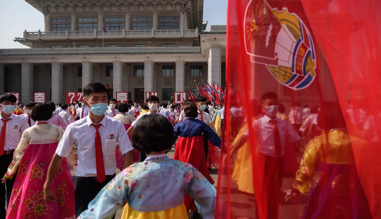 Para siswa ikut serta dalam 'pesta dansa' saat ke-68 berakhirnya Perang Korea di luar Grand Theatre di Pyongyang (27/7/2021). Dalam pengumuman terkoordinasi yang mengejutkan, Korea Utara dan Selatan mengungkapkan mereka telah sepakat untuk membuka kembali jalur komunikasi. (AFP/STR/KCNA VIA KNS)
