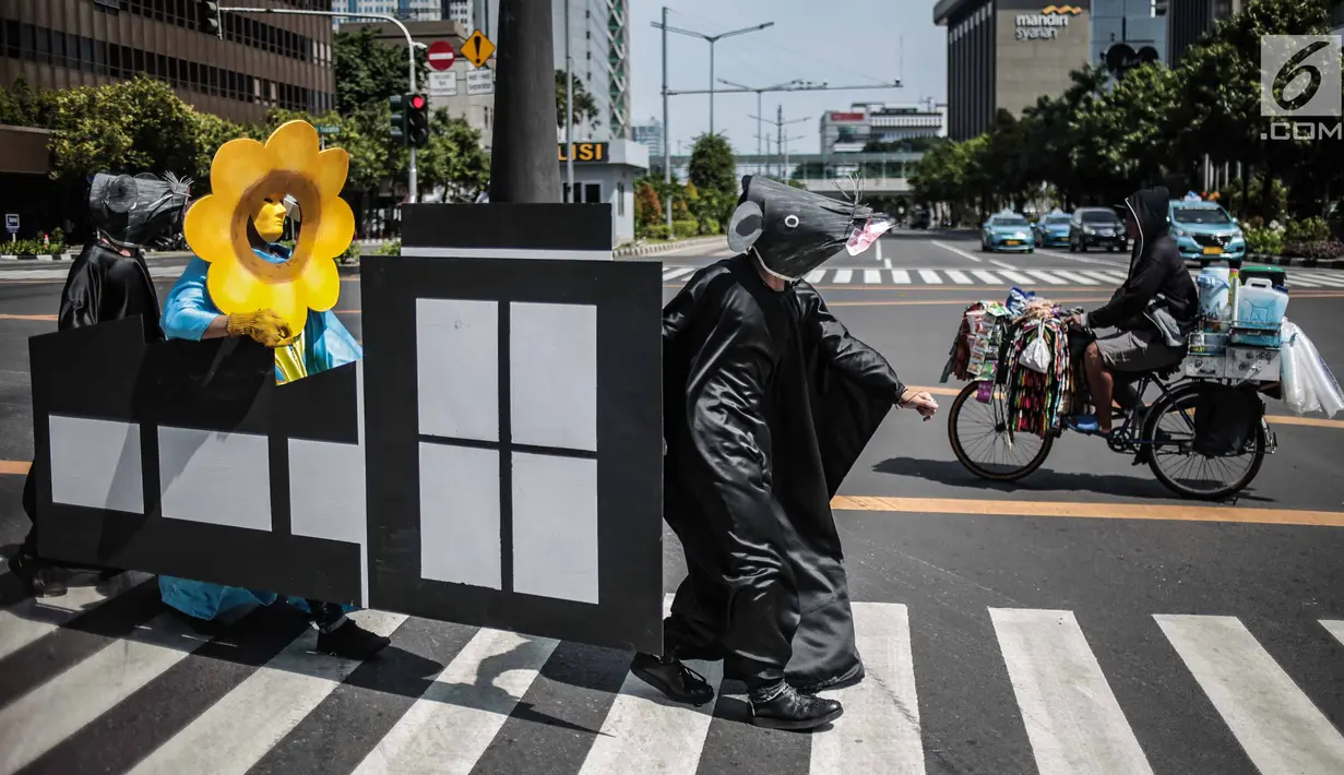 Massa menggelar aksi teatrikal di Pelican crossing di Jakarta, Kamis (20/12). Mereka mengajak pemilih milenial untuk memilih pemimpin yang berorientasi jangka panjang dan berpihak pada energi bersih, adil, dan berkelanjutan. (Liputan6.com/Faizal Fanani)