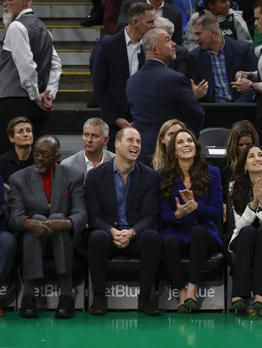 Pangeran Inggris William bersama Kate Middleton, Putri Wales , tertawa saat menyaksikan pertandingan NBA antara Boston Celtics dan Miami Heat di TD Garden di pusat kota Boston, pada 30 November 2022. (Photo By Winslow Townson/Getty Images)