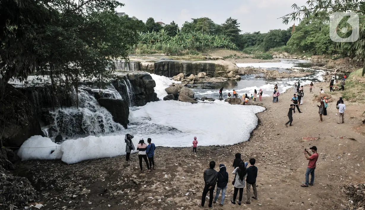 Wisatawan mengunjungi Curug Parigi yang tengah tercemar limbah busa di Cikiwul, Bantargebang, Bekasi, Jawa Barat, Minggu (19/7/2020). Destinasi wisata favorit warga Bekasi dan sekitarnya tercemar limbah sejak dua hari lalu sehingga menimbulkan busa dan bau tak sedap. (merdeka.com/Iqbal S. Nugroho)