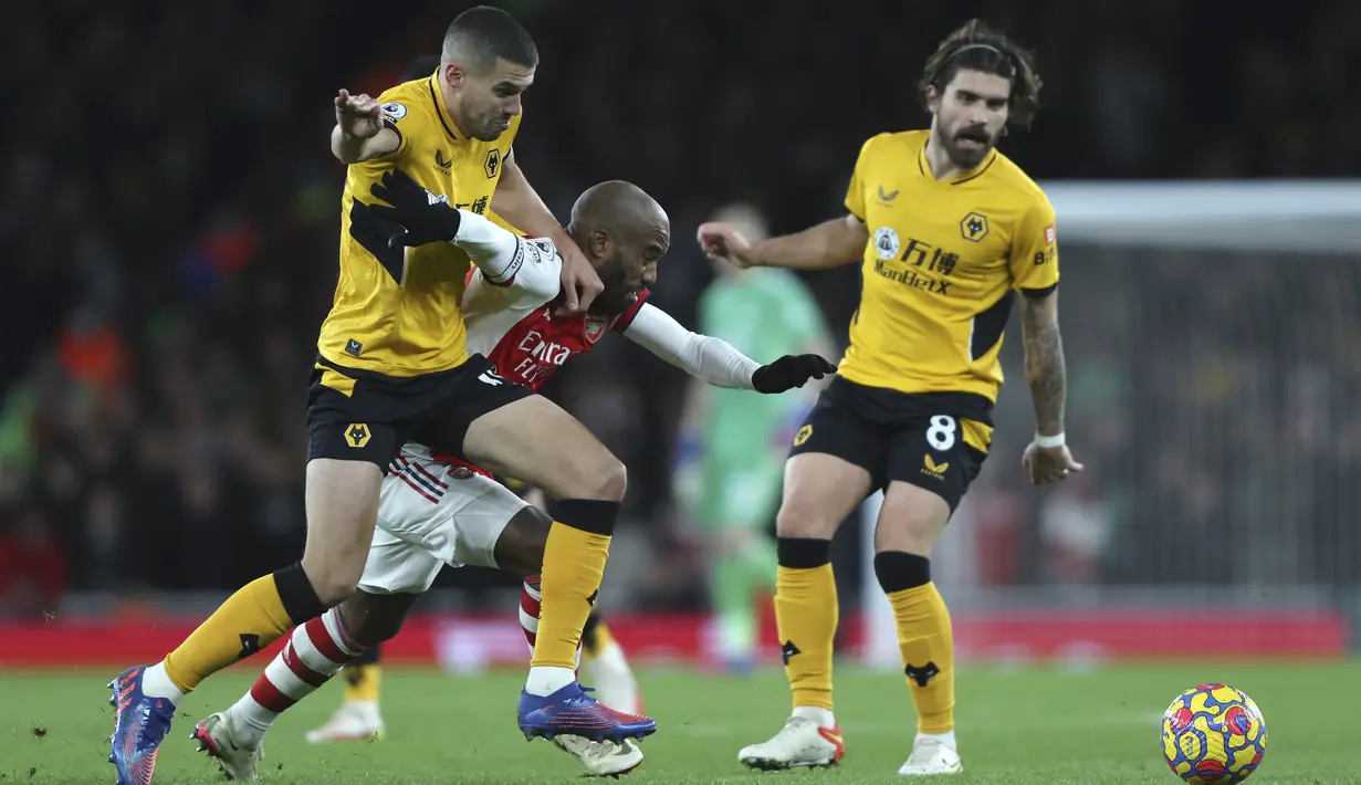 Bek Arsenal Rob Holding berebut bola dengan penyerang Wolverhampton Wanderers Raul Jimenez pada partai tunda pekan ke-20 Liga Inggris di Emirates Stadium, Jumat (25/2/2022) dini hari WIB. Arsenal menang dramatis 2-1 berkat dua gol di menit akhir. (AP Photo/Ian Walton)