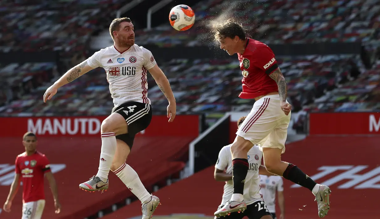 Bek Manchester United, Victor Lindelof, duel udara dengan pemain Sheffield United, John Fleck, pada laga Premier League di Stadion Old Trafford, Rabu (24/6/2020). Manchester United menang dengan skor 3-0. (AP/Martin Rickett)