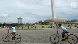 Anak-anak bermain sepeda saat sedang liburan di Monumen Nasional (monas), Jakarta, Selasa (25/12). Liburan Natal 2018, banyak warga datang bersama kerabat maupun keluarga memadati Monas. (Liputan6.com/Herman Zakharia)