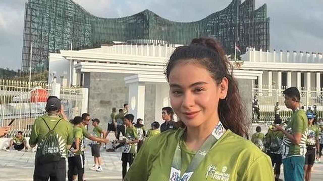 Sahila Hisyam mengenakan kaos hijau yang cerah, terlihat baru saja mengikuti event lari di IKN, dan berfoto dengan landmark khas daerah tersebut.<br>
