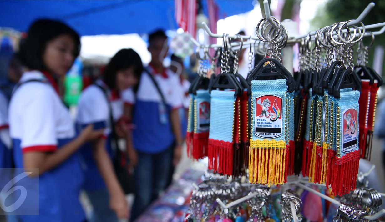 Salah satu anggota kontingen memilih pernak pernik PON XIX Jabar di GOR Universitas Pendidikan Indonesia, Senin (19/9). Beberapa pedagang memanfaatkan moment PON XIX Jabar untuk menjual beragam pernak pernik. (Liputan6.com/Helmi Fithriansyah)