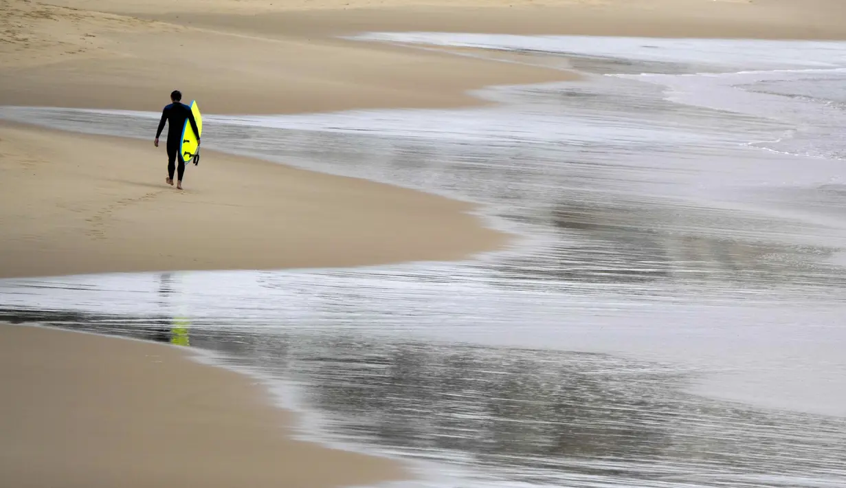 Seorang peselancar meninggalkan air di Pantai Bronte, Sydney, Australia, 24 Mei 2022. (AP Photo/Mark Baker)