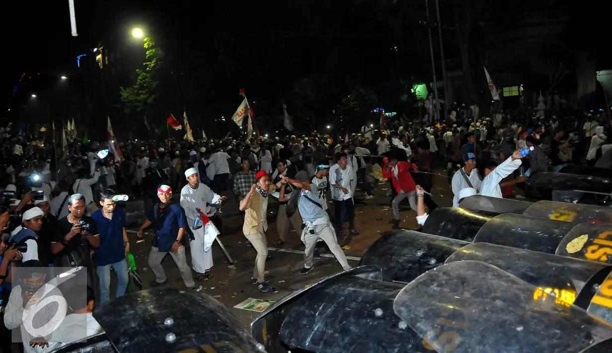 Massa Aksi Damai 4 November mencoba menerobos penjagaan dari petugas, Jakarta, Jumat (4/11). Belum diketahui apa yang menyebabkan terjadinya bentrokan dari aksi yang awalnya damai ini. (Liputan6.com/Angga Yuniar)