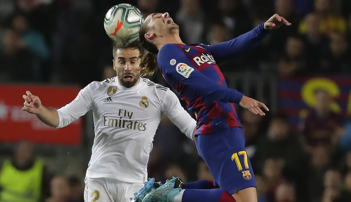 Penyerang Barcelona,  Antoine Griezmann berebut bola udara dengan bek Real Madrid, Dani Carvajal  pada pertandingan lanjutan La Liga Spanyol di stadion Camp Nou (18/12/2019). Barcelona bermain imbang 0-0 atas Real Madrid. (AP Photo/Joan Monfort)