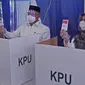 Calon Wali Kota Depok nomor urut 2 Mohammad Idris ditemani istrinya Elly Farida menggunakan hak pilih pada Pilkada 2020 di TPS 14 Jatimulya, Depok, Rabu (9/12/2020). Pilkada Depok 2020 diikuti oleh Pradi Supratna-Afifah Alia serta Mohammad Idris dan Imam Budi Hartono. (Liputan6.com/Herman Zakharia)