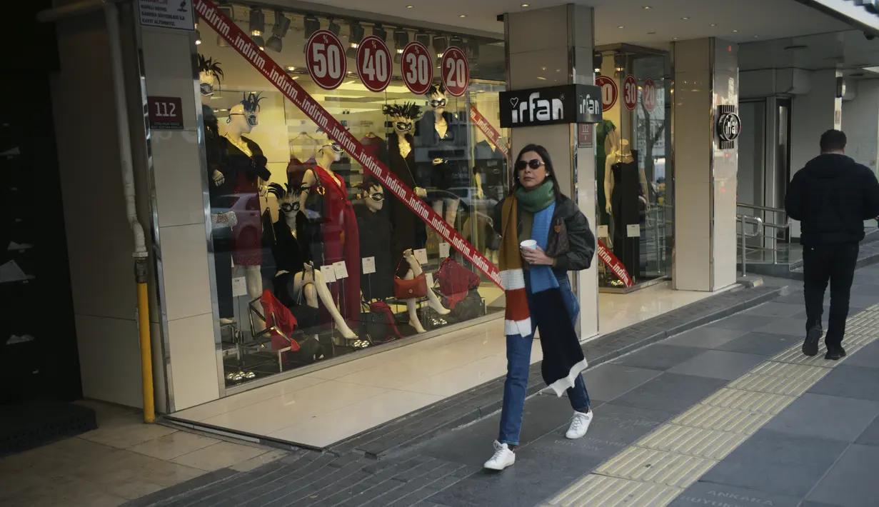 Seorang perempuan berjalan di jalan perbelanjaan populer di Ankara, Turki, Selasa, 3 Januari 2023. Inflasi Turki menunjukkan penurunan tajam pada Desember 2022. (AP Photo/Khalil Hamra)