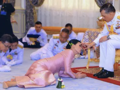 Raja Maha Vajiralongkorn (kanan) menyentuh kening Ratu Suthida saat prosesi pernikahan mereka di Bangkok, Thailand, Rabu (1/5/2019). Ini merupakan pernikahan keempat bagi Raja Thailand tersebut. (Thai TV Pool via Reuters)