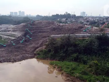 Foto udara memperlihatkan alat berat memindahkan tumpukan sampah dari Tempat Pembuangan Akhir (TPA) Cipeucang yang masuk ke area Sungai Cisadane, Serpong, Tangerang Selatan, Rabu (3/6/2020). Sebelumnya, pada Jumat (22/5/) lalu turap yang menopang TPA tersebut jebol. (Liputan6.com/Helmi Fithriansyah)