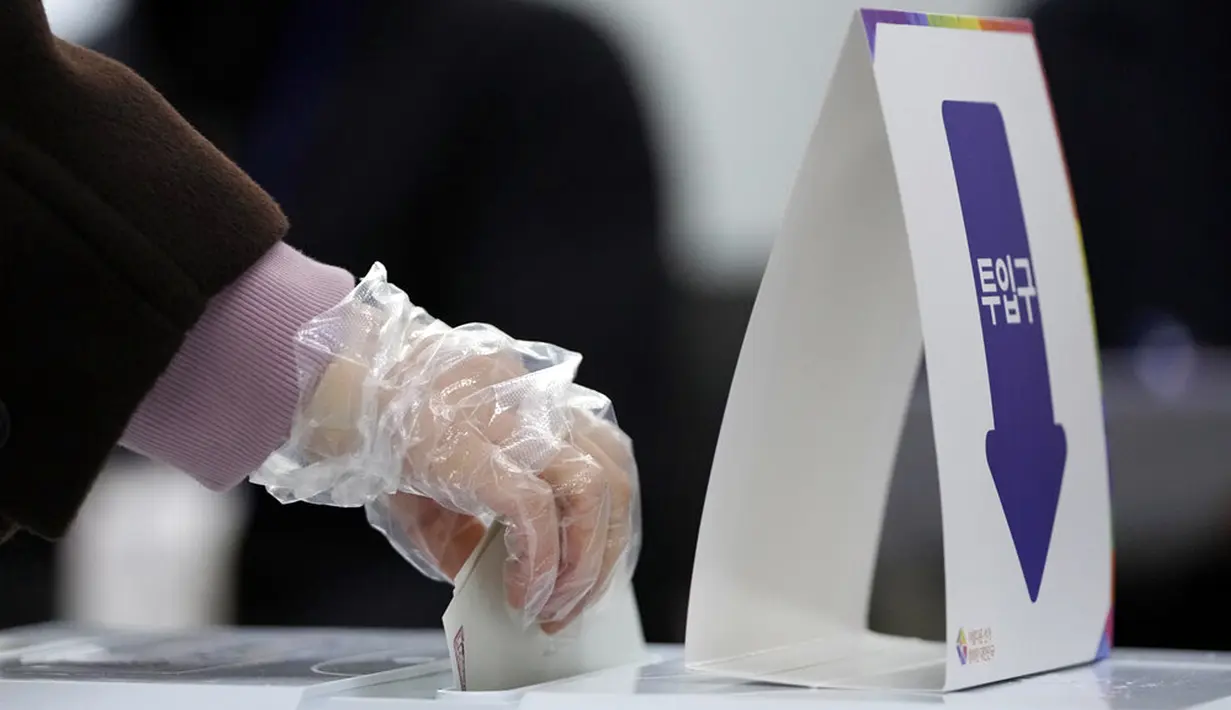 Pemilih mengenakan sarung tangan untuk mencegah COVID-19 saat memberikan suara pada pemilihan presiden di TPS lokal di Seoul, Korea Selatan, 9 Maret 2022. Korea Selatan mulai pemilihan presiden dengan mempertarungkan Lee Jae-myung dan Yoon Suk-yeol. (AP Photo/Lee Jin-man)