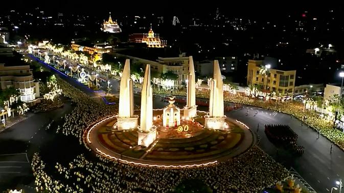 Suasana saat Raja Thailand Maha Vajiralongkorn mengelilingi Monumen Demokrasi dalam arak-arakan di Kota Bangkok, Thailand, Minggu (5/5/2019). Arak-arakan menempuh jarak 7 kilometer yang membawa raja ke muka publik Thailand untuk pertama kalinya. (Pool TV Thailand via AP)