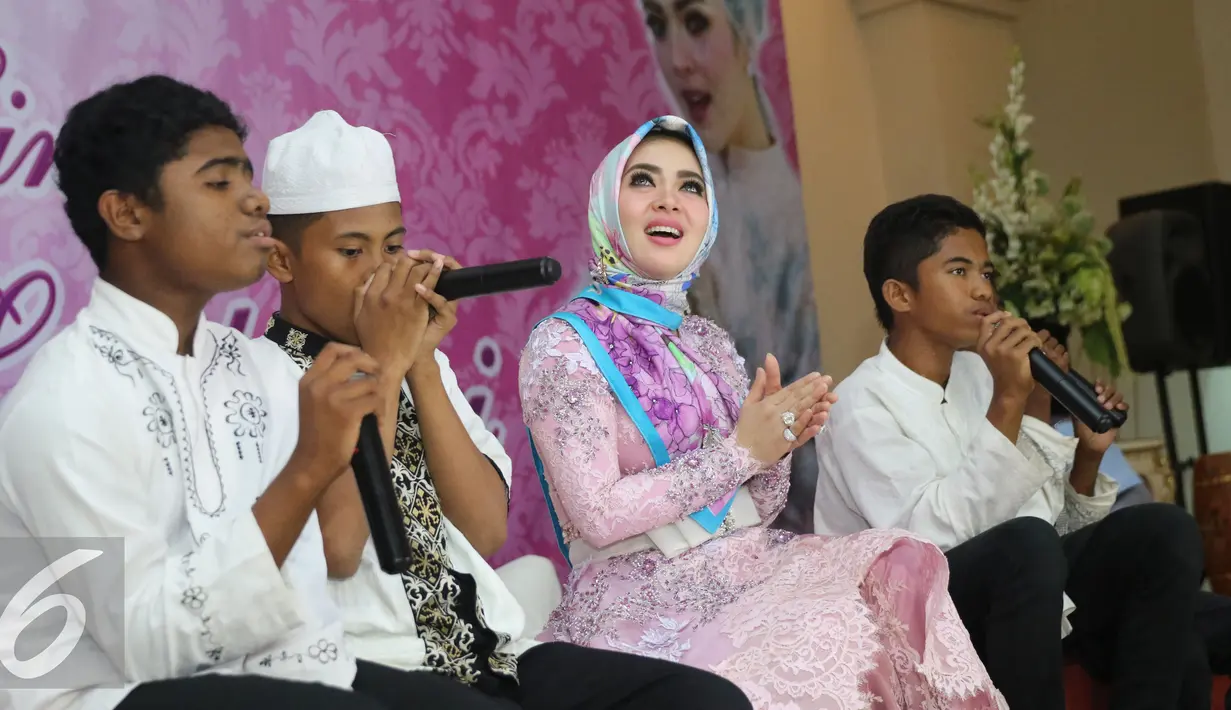 Penyanyi Syahrini saat buka puasa bersama dengan anak yatim piatu di Masjid Az-Zikra, Sentul, Bogor, Jumat (24/6). Syahrini berbagi rezeki dengan 5.000 anak yatim.  (Liputan6.com/Herman Zakharia)