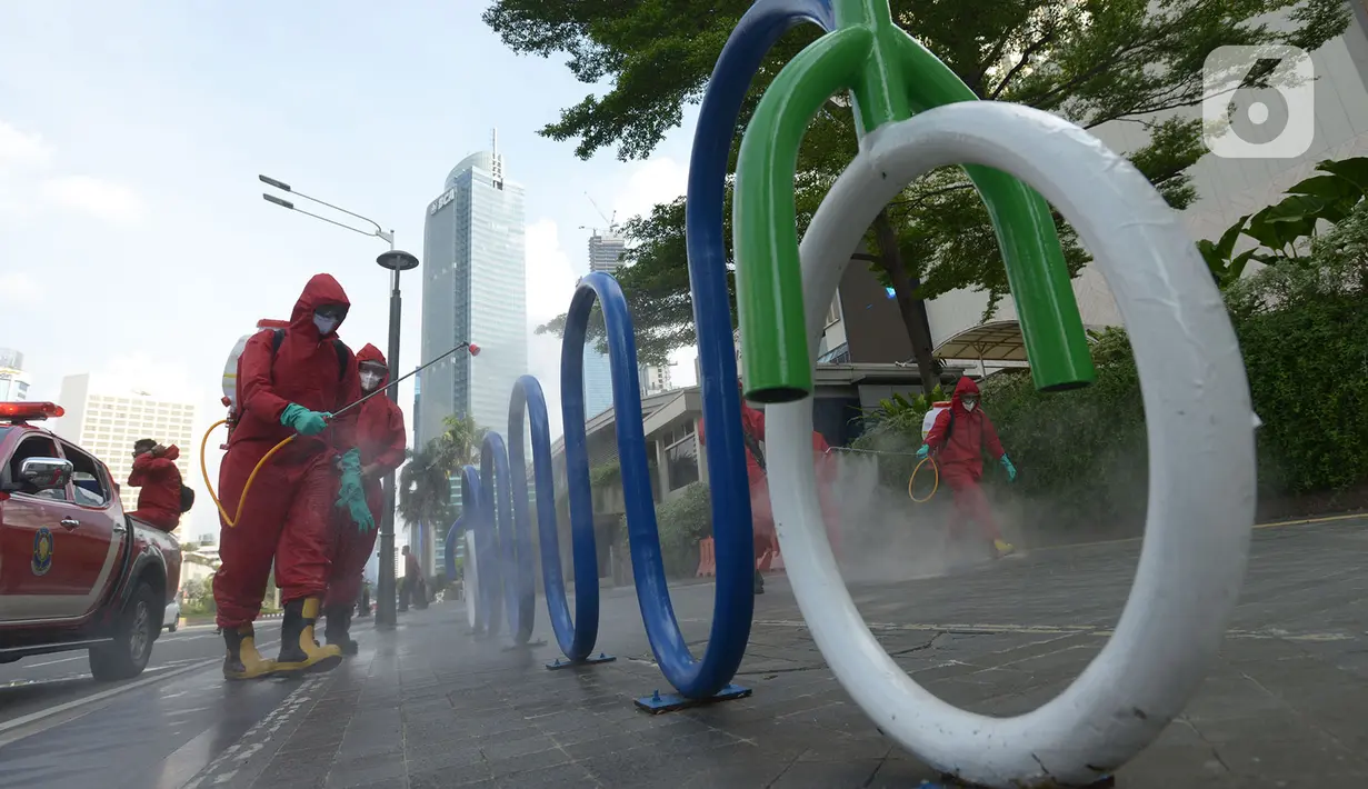 Petugas pemadam kebakaran (Damkar) melakukan penyemprotan disinfektan di sepanjang jalan Jenderal Sudirman-MH Thamrin, Jakarta, Sabtu (20/6/2020). Penyemprotan dalam rangka kembali diadakannya Car free day di Jalan Sudirman-Thamrin pada Minggu, 21 Juni esok. (merdeka.com/Imam Buhori)