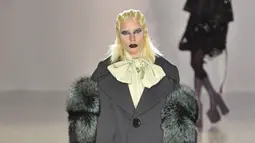 Lady Gaga tampil dengan oversize coat sambil menenteng tas saat menjadi model untuk Marc Jacobs pada acara New York Fashion Week, Kamis (18/2). Gaga tampil dengan eyeliner dan lipstik hitam. (Slaven VLASIC/Getty IMAGES NORTH AMERICA/AFP)