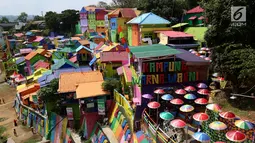 Suasana kampung warna-warni dari atas jembatan di Kelurahan Kesatrian, Kota Malang, Minggu (5/11). Ratusan rumah yang berdiri di bantaran Sungai Brantas di cat gambar warna-warni. (Liputan6.com/Fery Pradolo)