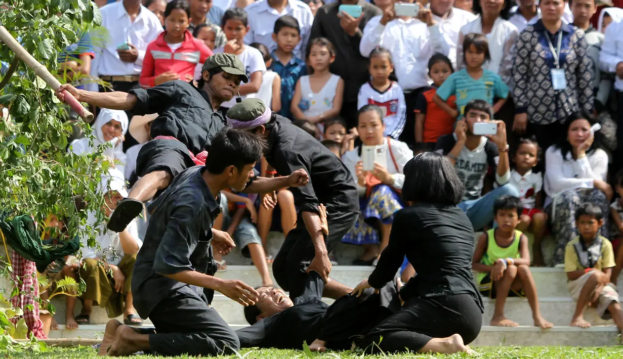 Sejumlah aktor memperagakan pembunuhan massal yang dilakukan prajurit Khmer Merah saat berkuasa di  Phnom Penh, Kamboja, (20/5). Perayaan ini dipusatkan di depan Choeung Ek, museum Killing Fields di pinggiran Phnom Penh. (REUTERS/Samrang Pring)