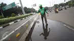 Pengendara Gojek bernama Ari mencari ranjau paku yang berserakan di sekitar Istana Negara, Jakarta, Minggu (14/8). Meskipun tak dibayar, Ari berinisiatif untuk mengumpulkan ranjau paku yang merugikan pengendara tersebut. (Liputan6.com/Immanuel Antonius)