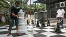 Warga bermain catur raksasa sambil menunggu waktu berbuka puasa di Pondok Betung, Tangerang Selatan, Kamis (14/5/2020). Tinggi bidak catur 50-86 cm dengan diameter sekitar 35 cm terbuat dari bahan viber glass dengan luas lapangan 4,8m x 4,8m. (Liputan6.com/Fery Pradolo)