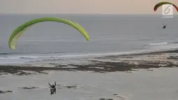 Wisatawan melakukan tandem paralayang yang difasilitasi operator Riug Paragliding di Bukit Riug, Nusa Dua, Bali (30/6). Setiap wisatawan dikenai tarif 110 dollar/ orang untuk penerbangan selama 15 menit. (Merdeka.com/Arie Basuki)