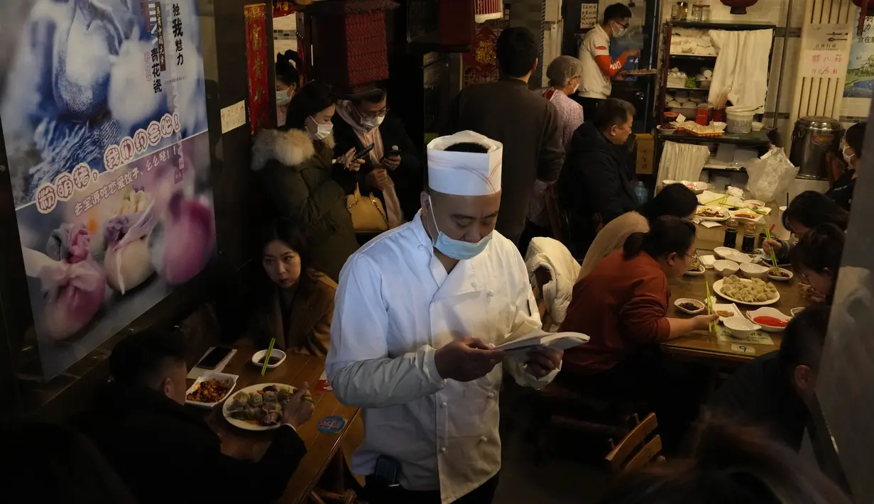 Seorang pekerja bersiap untuk melayani pelanggan di sebuah restoran yang terkenal dengan pangsitnya selama hari titik balik matahari musim dingin di Beijing, China, Selasa (21/12/2021). Pangsit adalah makanan festival selama hari titik balik matahari musim dingin. (AP Photo/Ng Han Guan)