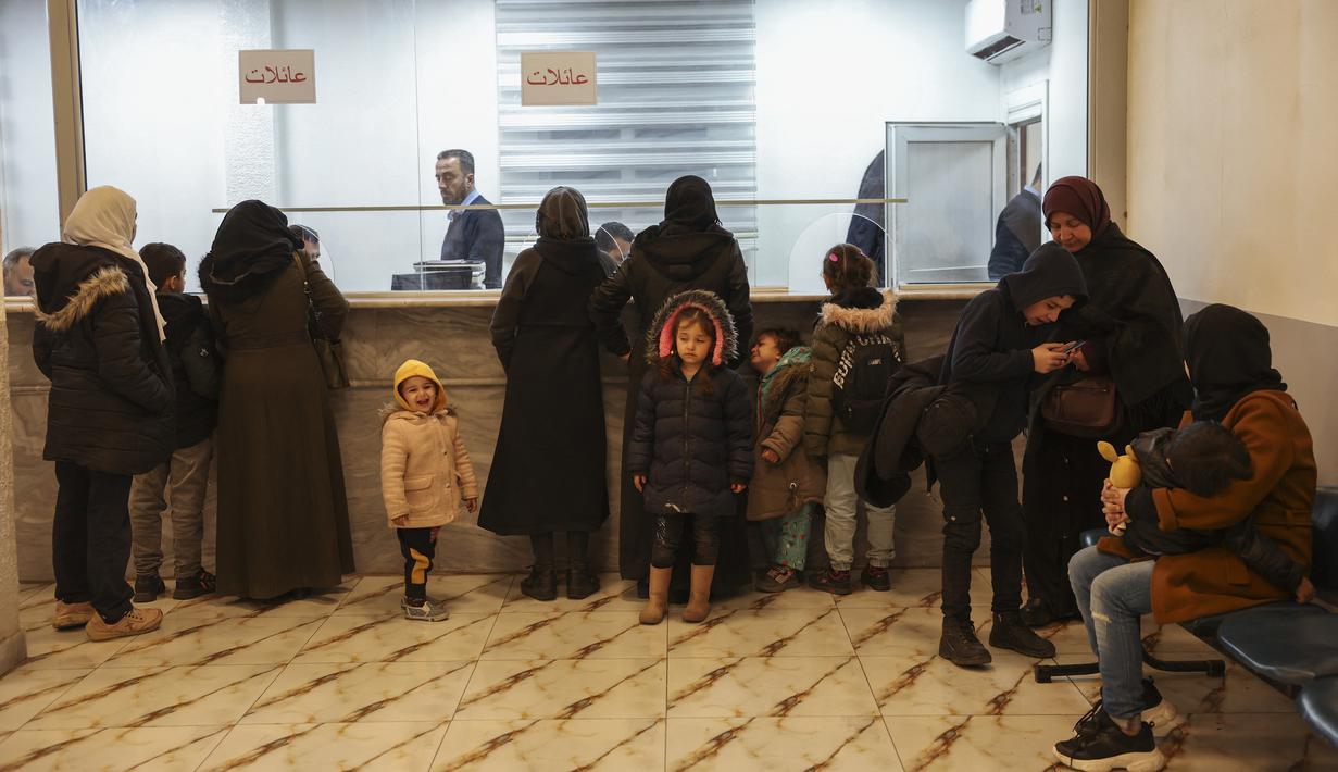 Pengungsi Suriah yang tinggal di Turki menunggu saat para pejabat memeriksa surat-surat mereka di perbatasan utara Bab al-Hawa, pada 17 Februari 2023, saat mereka kembali ke Suriah setelah gempa bumi yang mematikan. Perubahan aturan yang dirancang untuk menyatukan kembali keluarga di kedua sisi perbatasan yang dilanda bencana 6 Februari, yang telah menewaskan lebih dari 41.000 orang dan membuat jutaan orang mengungsi di kedua negara. (AFP/Omar Haj Kadour)