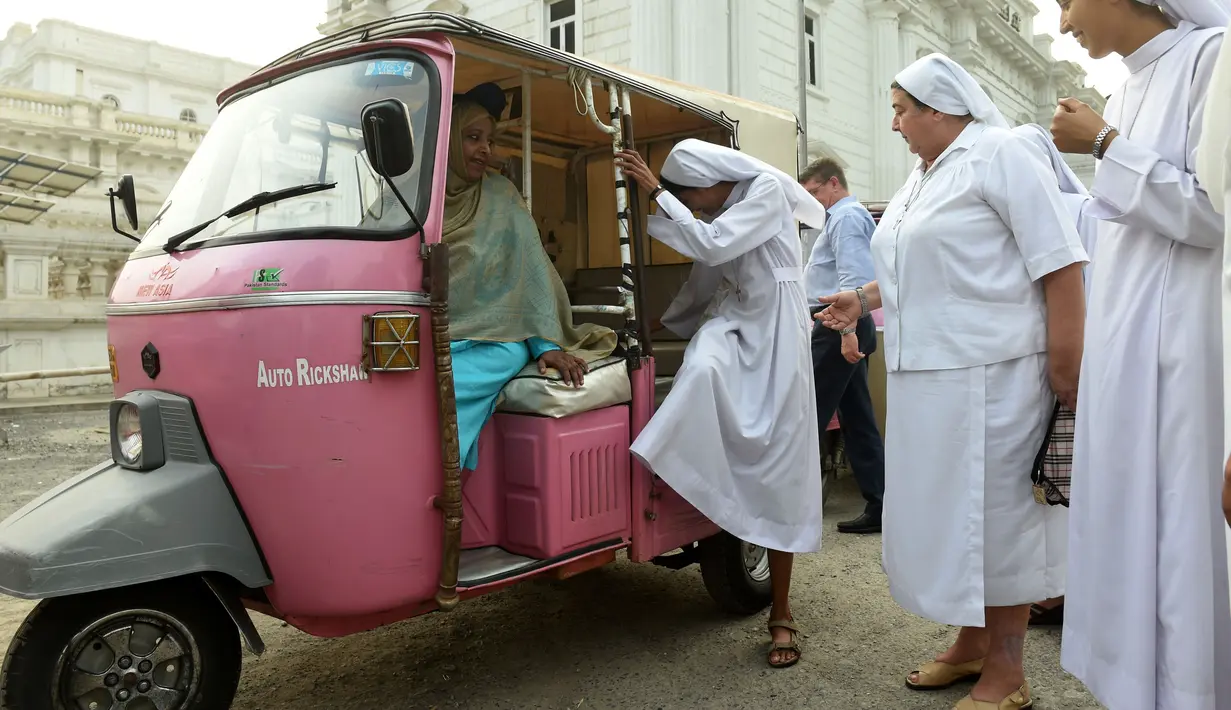 Para biarawati Pakistan melihat-lihat sembari menaiki becak merah muda sebelum aksi untuk meningkatkan kesadaran wanita, menunjukkan kesetaraan dan pemberdayaan perempuan di Lahore, (14/10). (AFP PHOTO / Arif Ali)