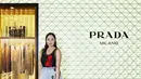 Tatjana Saphira terlihat menarik dengan black patterned sleeveless top yang dipadukan dengan light blue printed midi skirt. Look ini kita maksimal dengan padanan white heeled boots dari Prada. / Foto dok: Prada.